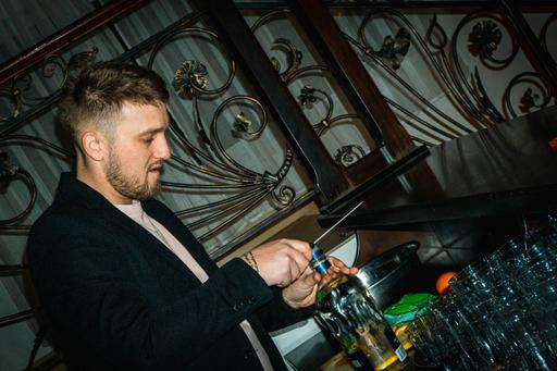Florin măsoară ingredientele cu un jigger în timpul preparării unei băuturi